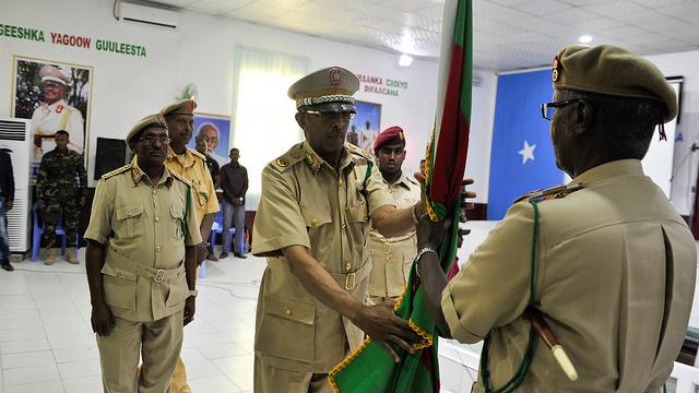 Men in uniform stand with a flag